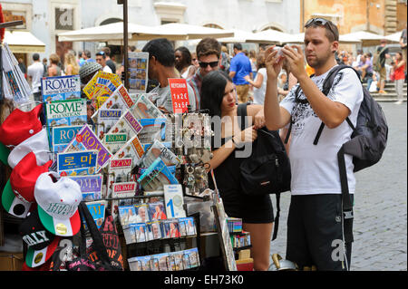 Un jeune homme d'admirer un souvenir d'une stalle, Rome, Italie. Banque D'Images