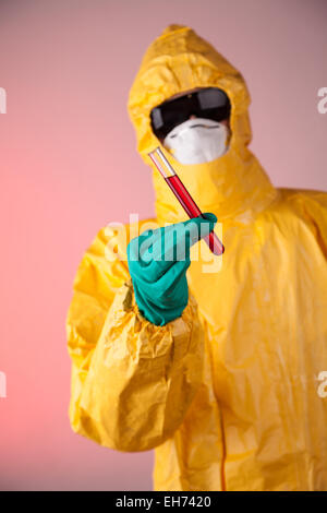 Homme de laboratoire en robe de protection chimique holding vial of blood sample Banque D'Images