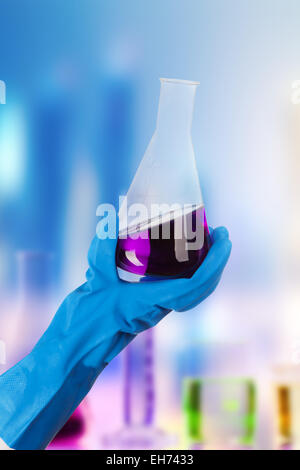 Hand holding liquide chimique en laboratoire dans un flacon de verre Banque D'Images