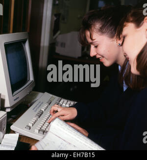 Adolescentes élèves des années 1990 travaillant sur l'utilisation d'un ordinateur pour le travail scolaire dans une classe secondaire de technologie de l'information à l'école secondaire de Ysgol Pantycelyn lycée à Llandovery Carmarthenshire pays de Galles Royaume-Uni Grande-Bretagne KATHY DEWITT Banque D'Images