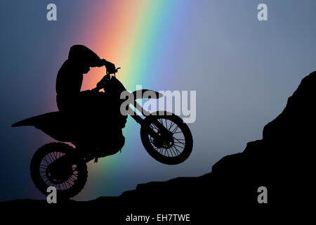 Motocross - silhouette avec arc-en-ciel de couleurs dans le ciel Banque D'Images