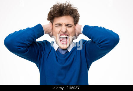 Beau jeune homme en criant et en couvrant ses oreilles Banque D'Images