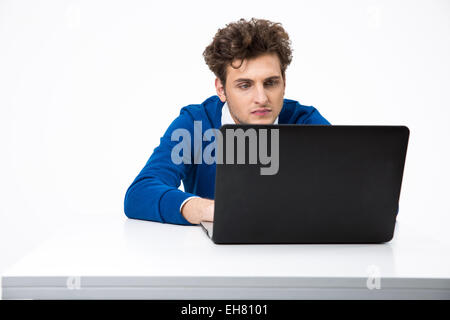 Homme sérieux travaillant sur l'ordinateur portable sur fond blanc Banque D'Images