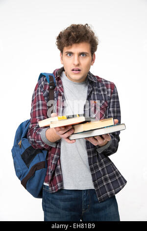 Jeune homme surpris avec des livres sur fond gris Banque D'Images