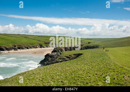 Les promeneurs sur le chemin de la côte au-dessus de la plage de Porth Joke près de Newquay en Cornouailles sur une journée de printemps ensoleillée. Banque D'Images