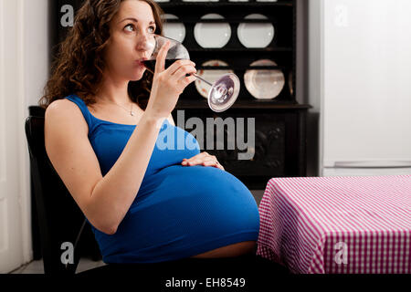 Femme en pleine période de la grossesse l'alcool du vin rouge. Banque D'Images