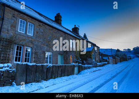 Cottages en pierre, sur chemin de campagne à l'heure bleue, les chutes de neige fraîche, Curbar, parc national de Peak District, Derbyshire, Angleterre Banque D'Images