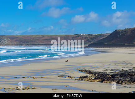 Femme et chien appréciant la solitude de Sennen Cove, Cornwall, England UK Banque D'Images
