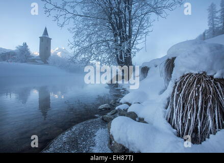 La glace et le givre couvrant les rives de la rivière Inn en Basse-engadine, église à Sils, Grisons, Suisse Banque D'Images