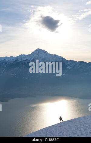 Silhoutte of mountain range at sunset un randonneur face au Mont Legnone au coucher du soleil et le lac de Côme, Lombardie, Italie, Europe Banque D'Images