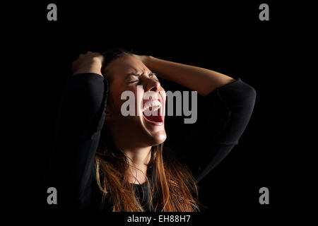 Femme pleurant et criant déprimé désespérément isolé dans un fond noir Banque D'Images