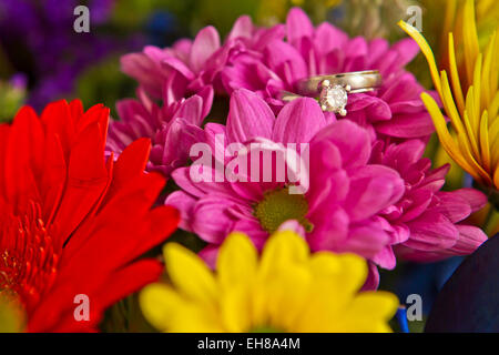 Les anneaux de mariage reposant sur jolies fleurs roses Banque D'Images