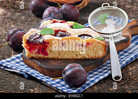 Délicieux gâteau fait maison avec des prunes sur un fond de bois Banque D'Images