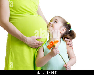 Happy Child holding flower examine pregnant mother Banque D'Images