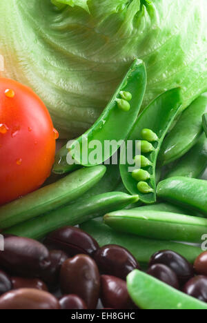 Les ingrédients pour les salades. Sugar snaps, tomate, laitue et les olives noires. Banque D'Images