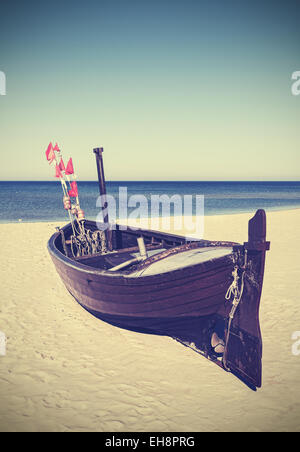 Retro photo filtrée de bateau de pêche sur la plage. Banque D'Images