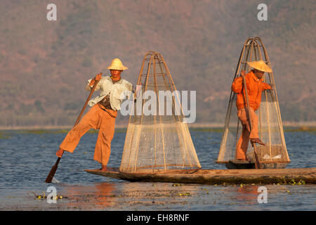 Jambe deux pêcheurs pêche, aviron au Lac Inle, Myanmar ( Birmanie ), l'Asie Banque D'Images