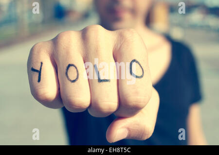 Libre d'un jeune homme avec le mot yolo, on ne vit qu'une fois, tatoué sur sa main, avec un effet de filtre Banque D'Images