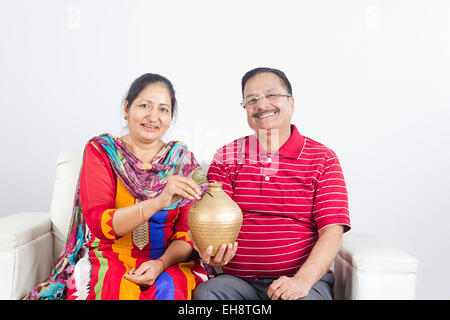 2 couples mariés aînés indiens assis canapé Tirelire d'économiser de l'argent Banque D'Images