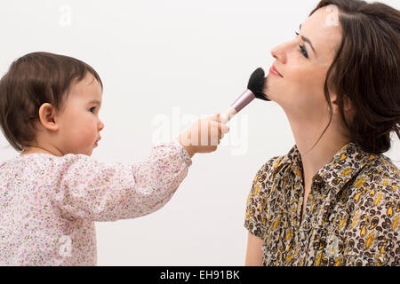 Petite fille jouant avec son maquillage de maman