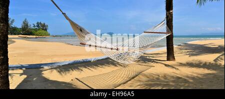 Hamac dans l'ombre de palmiers au Tropical Beach Banque D'Images