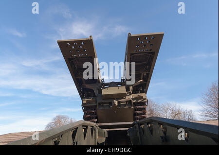 Vue imposante comme un puissant lancer assault tank transportant une plate-forme mobile en acier se déplace au-dessus d'un pont temporaire au-dessous de la pente Banque D'Images