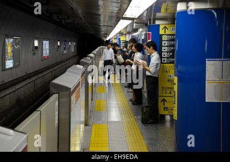 La gare de métro de plate-forme avec les banlieusards de Tokyo Japon Banque D'Images