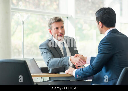 Businessmen shaking hands in meeting Banque D'Images