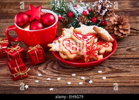 Les cookies de Noël se trouve à la main sur fond de bois. Banque D'Images