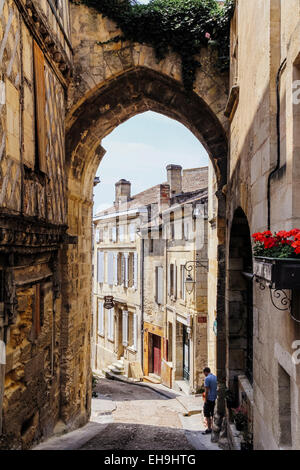 Jeune homme en vertu de l'arche sur la rue à Saint-Emilion, Gironde, Aquitaine, France Banque D'Images