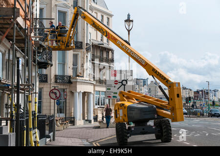 Deux ouvriers de l'inspection d'un bâtiment à partir d'une plate-forme de travail à Brighton Banque D'Images