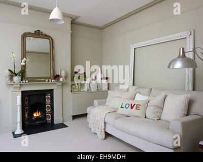 Canapé blanc en face de feu ouvert dans le salon blanc, maison d'habitation, Port Hall Street, Brighton, East Sussex, UK Banque D'Images