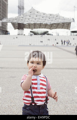 Bébé garçon mangeant à l'extérieur de cookie Banque D'Images