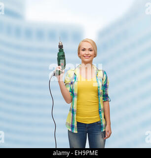Femme souriante avec perceuse Banque D'Images