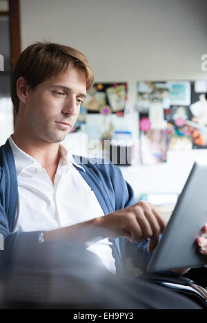 Man using digital tablet in office Banque D'Images