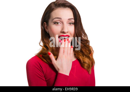 Jolie femme en rouge à l'écart dans la crainte surpris avec la bouche grande ouverte isolé sur fond blanc Banque D'Images