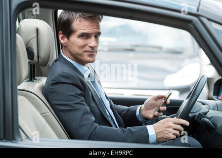 Homme texter au volant voiture Banque D'Images