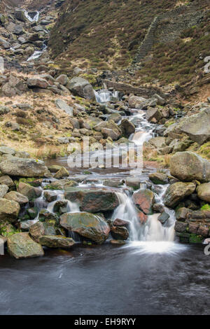 Un petit ruisseau Tumbling sur fallen millstone grit blocs dans une vallée dans le Nord de la région de Peak District près de Saddleworth Banque D'Images