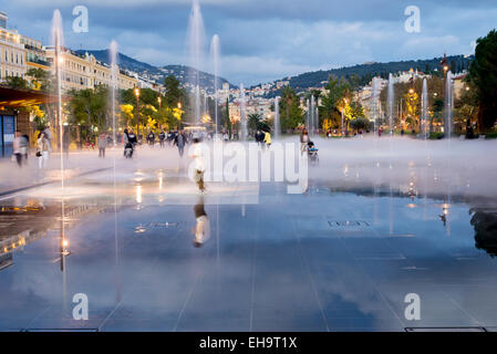 Juste à côté de la vieille ville est une grande aire restaurée avec des fontaines et de la brume aire de jeu, la Place Massena, Nice, France Banque D'Images