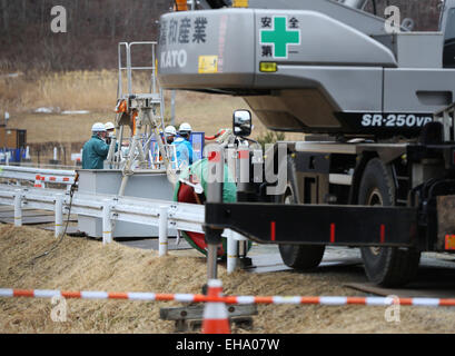 (150310) -- Fukushima, le 10 mars 2015 (Xinhua) -- Les travailleurs ont vu derrière de grands équipements dans la ville d'Iitate, préfecture de Fukushima, au Japon, le 7 mars 2015. Les scènes des villes et villages abandonnés encore quatre ans après le séisme qui a déclenché le tsunami a violé les défenses de la centrale nucléaire de Fukushima Daiichi, pourrait contribuer à la toile de fond parfaite pour un film de zombie Hollywood apocalyptiques, mais le problème serait que les niveaux de rayonnement dans la zone serait trop dangereux pour la distribution et l'équipe. Le gouvernement central de la maxime "Tout est sous contrôle' dans et arou Banque D'Images