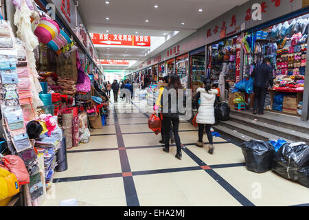 Hangzhou, Chine - décembre 5, 2014 : l'intérieur du marché de vêtements chinois ordinaire avec quelques acheteurs et vendeurs Banque D'Images