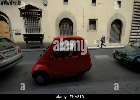 Un petit rouge-personne (trois roues) electric Pasquali Riscio voiture garée dans la rue, Florence, Italie Banque D'Images
