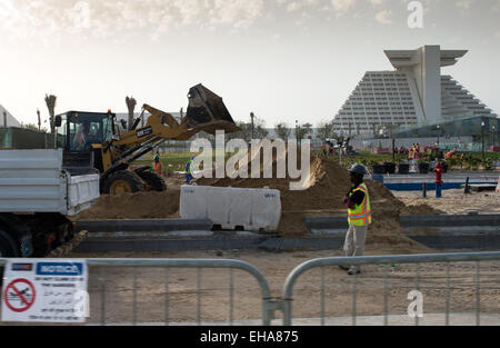 Doha, Qatar. Mar 10, 2015. Vue des constructeurs et véhicules de construction au travail sur un chantier à Doha, Qatar, le 10 mars 2015. Qata est d'accueillir la Coupe du monde 2022. Le Qatar a attiré les critiques internationales concernant le vote d'accueillir la Coupe du monde et sur les conditions de travail des travailleurs de la construction étrangers et buiders. Photo : Bernd von Jutrczenka/dpa/Alamy Live News Banque D'Images