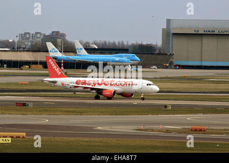 Easyjet prêt au décollage à l'aéroport de Schiphol Amsterdam, deux avions klm à l'arrière-plan Banque D'Images