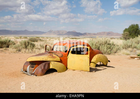 Voiture abandonnée près d'une station-service at solitaire dans le désert du Namib, Namibie. Banque D'Images