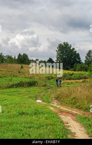 Les gars aller par des vélos sur le chemin vers le village. Banque D'Images