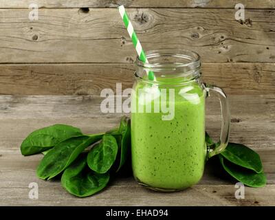 Smoothie vert sain avec les épinards dans un pot mug contre un arrière-plan bois Banque D'Images