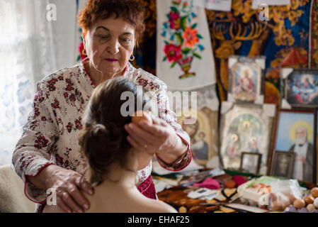 Milinchuk Halina, praticien de médecine alternative, guérir son patient, roulant sur son corps et l'orthographe Duo-Pagan-Christian Koziatyn théiste, prière, région Vinnytsia, Ukraine Banque D'Images