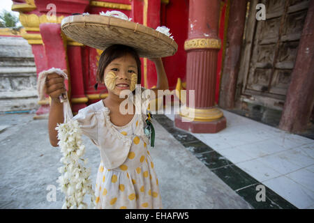 Jeune fille au temple Kuthodaw Paya à Mandalay, Myanmar, la vente de fleurs pour les offrandes Banque D'Images
