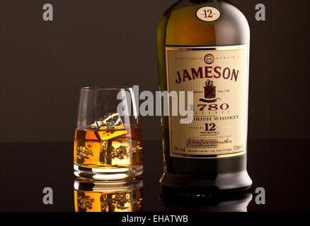 Bouteille de whisky Jameson et le verre avec des glaçons. Banque D'Images